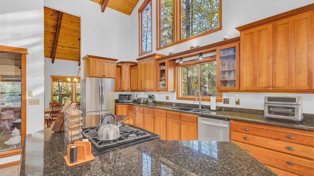Open kitchen with granite counters and tall windows